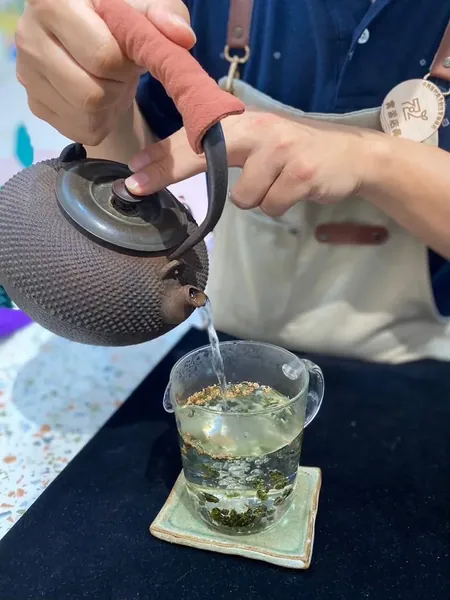 用鐵壺把熱水注入裝著茶葉的玻璃茶海